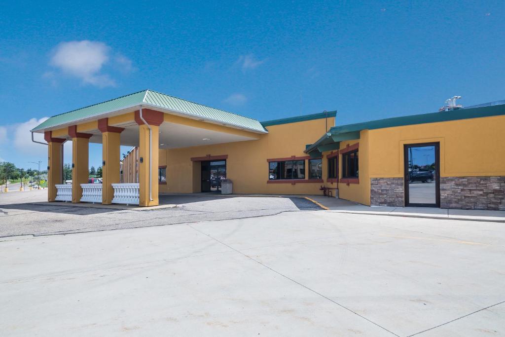 um grande edifício amarelo com um gazebo em Badlands Inn & Suites em Dickinson