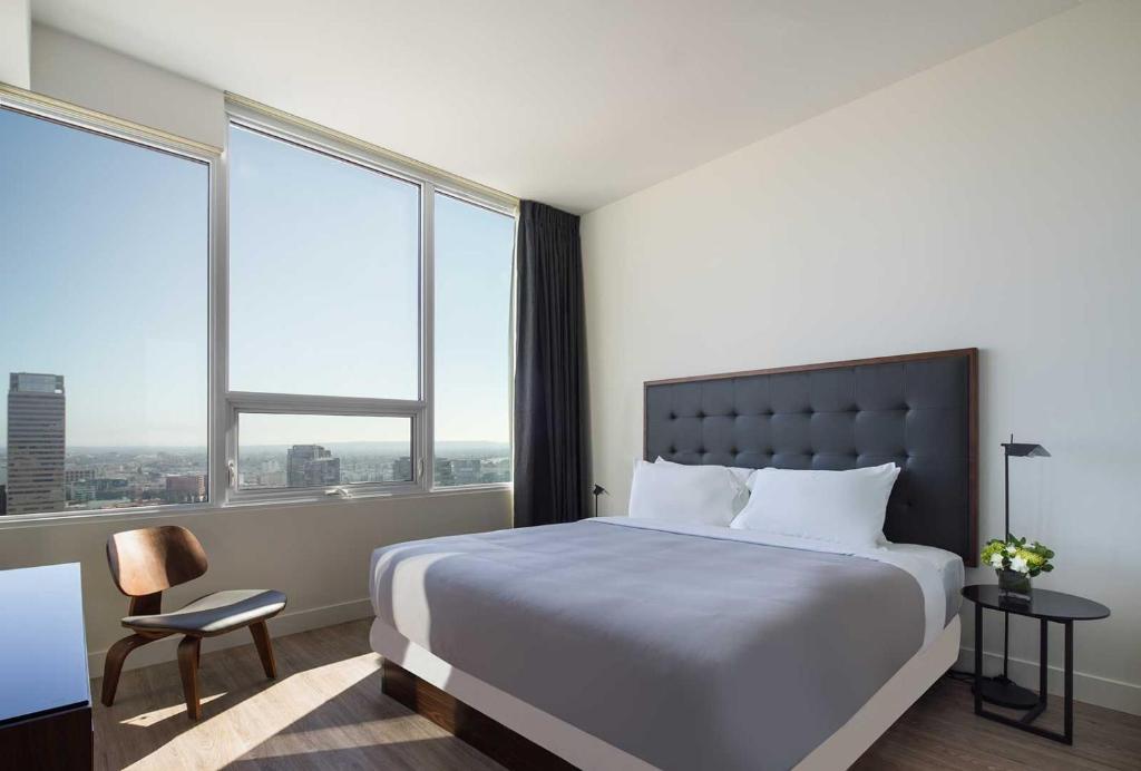 a bedroom with a large bed and large windows at Luxurious Highrise 2b 2b Apartment Heart Of Downtown LA in Los Angeles