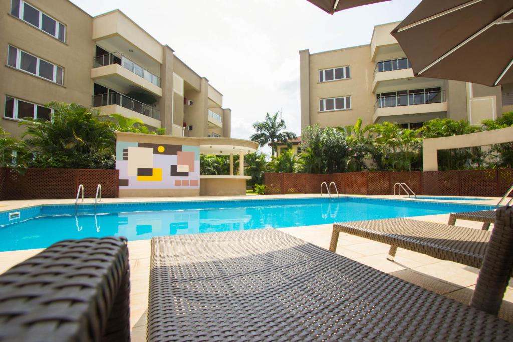 a swimming pool with chairs and a building at 90 Independence Avenue in Accra