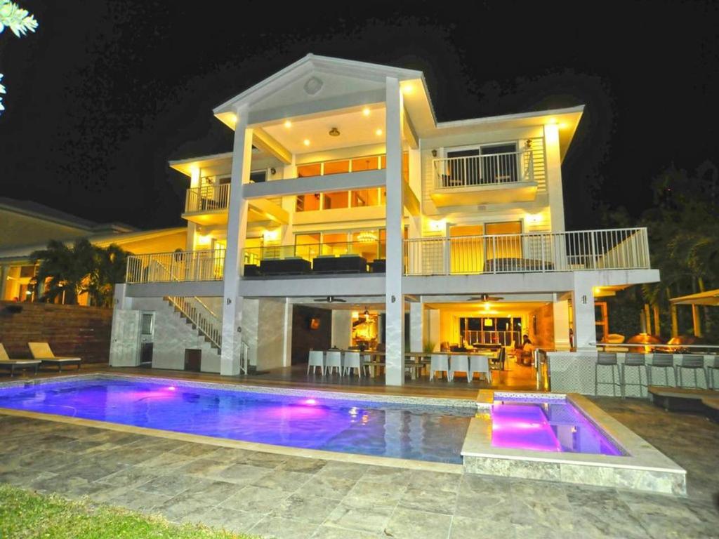 una grande casa con piscina di notte di Villa Estelle a Miami