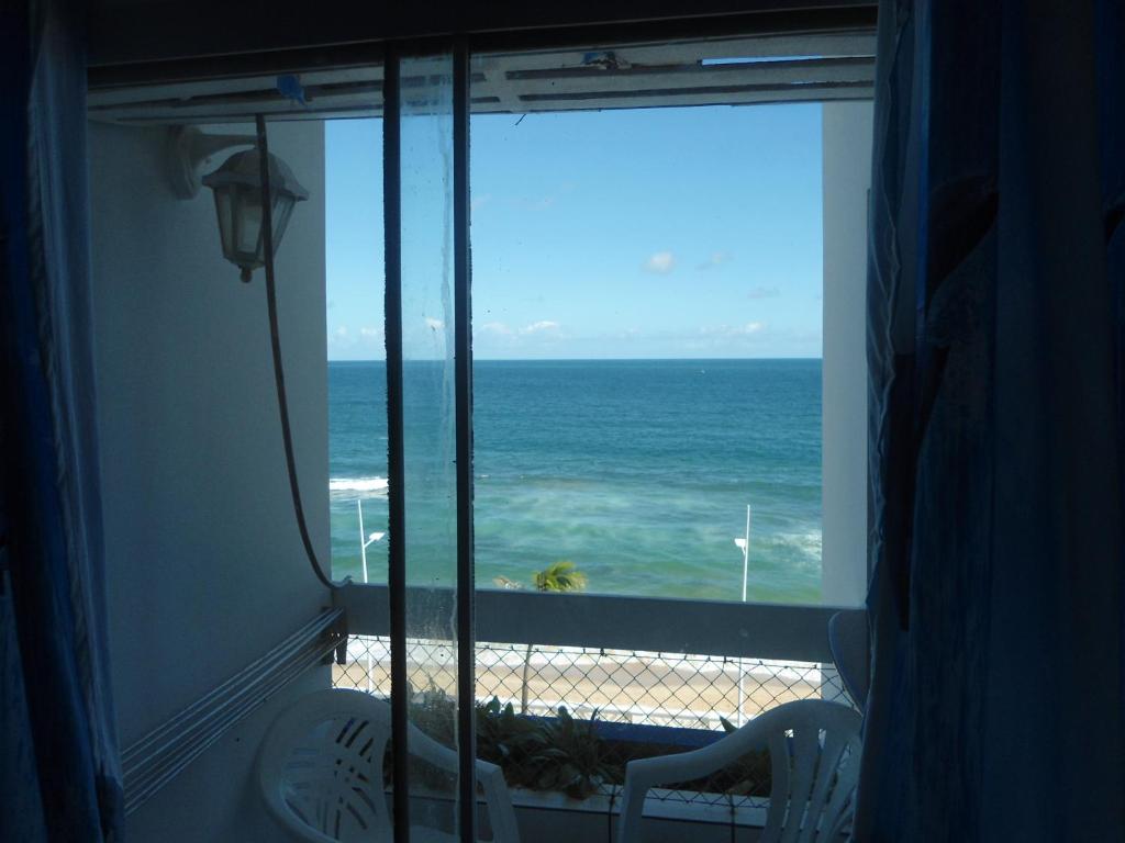 um quarto com vista para o oceano a partir de uma janela em Bahia Flat ap. 311 em Salvador