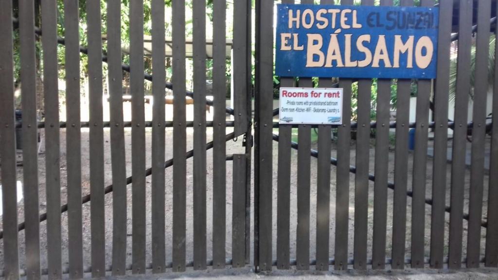 ein Schild auf einem Zaun mit einem Schild drauf in der Unterkunft Hostal El Balsamo in El Sunzal