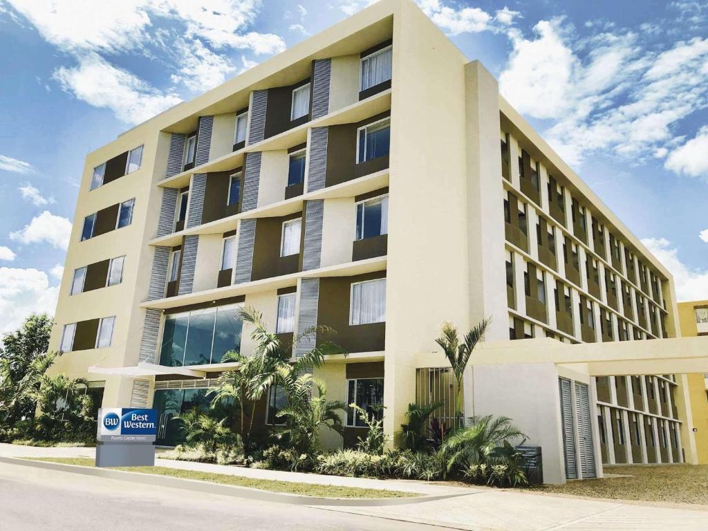 un gran edificio blanco con palmeras delante en Best Western Puerto Gaitan, en Puerto Gaitán