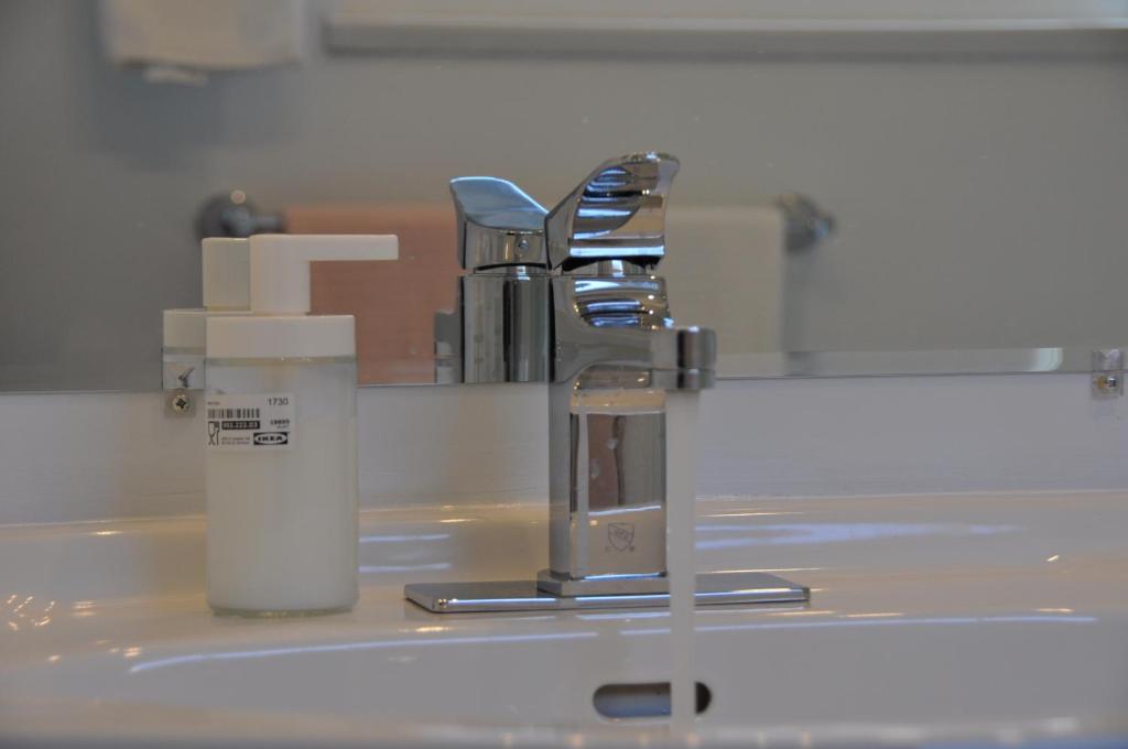 a bathroom with a sink with two chairs and a mirror at Bed Plus YVR in Richmond