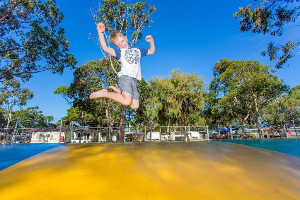 a boy jumping high into the air on top of a surfboard at Ingenia Holidays Torquay Australia in Torquay