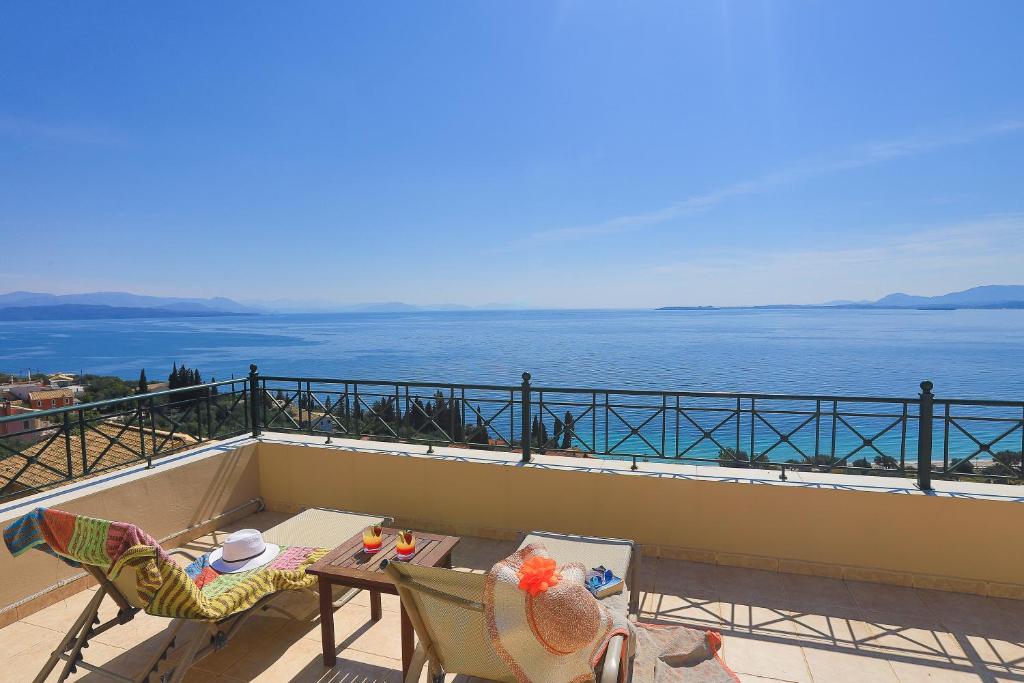 uma varanda com uma mesa e cadeiras e o oceano em Villa Dimeli em Barbati