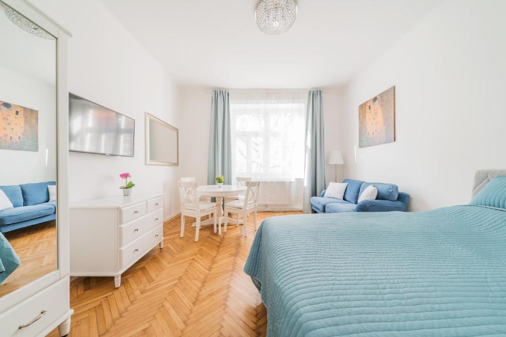1 dormitorio con 1 cama azul, mesa y sillas en Herzlich Willkommen - Küss die Hand 2 en Viena