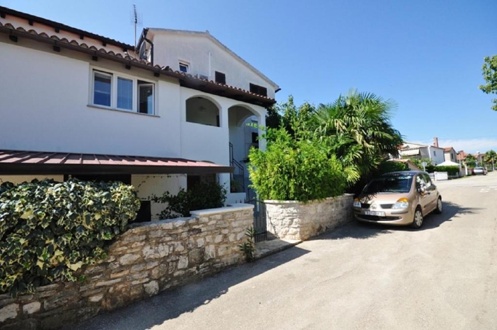 un'auto parcheggiata di fronte a una casa di Mira Apartments a Novigrad Istria