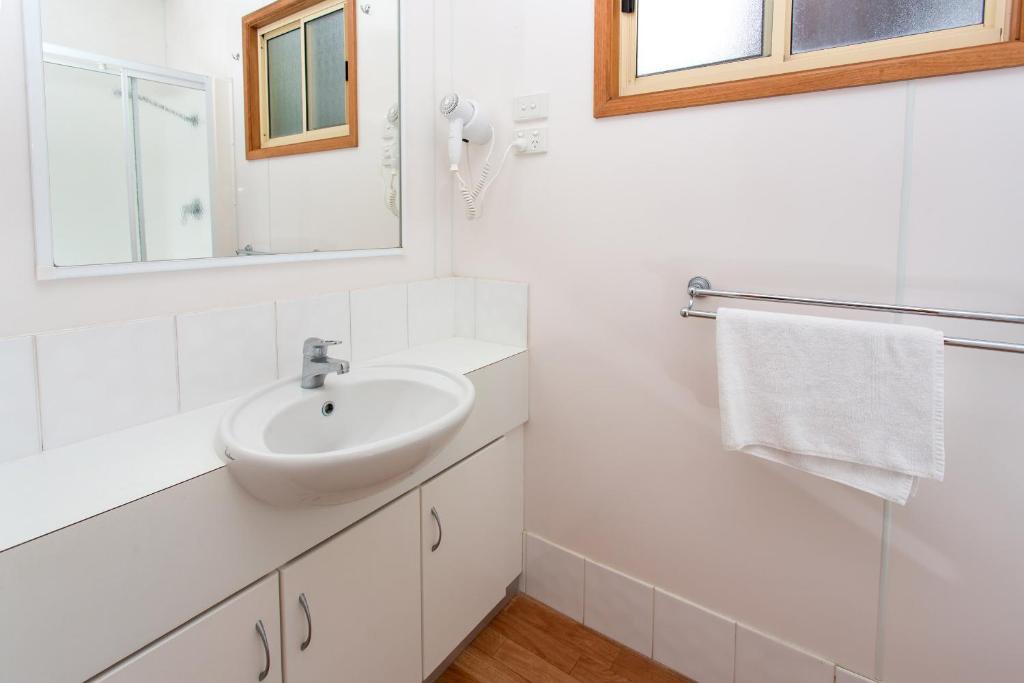 a white bathroom with a sink and a mirror at Ingenia Holidays Torquay Australia in Torquay