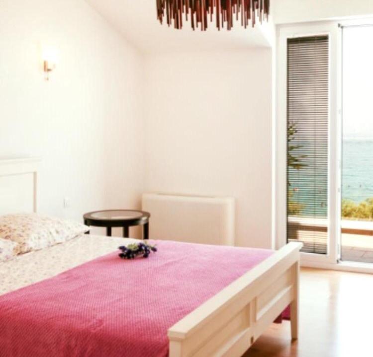 a bedroom with a large bed with a pink blanket at Penthouse Apartments Ana in Sutivan