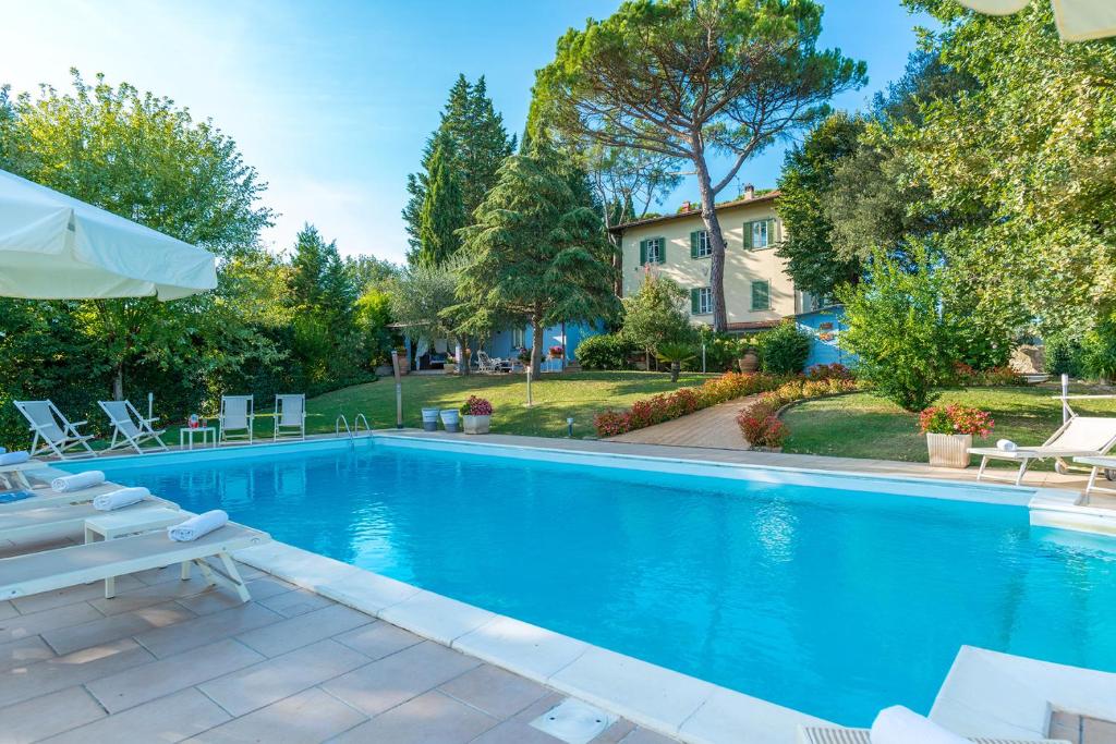 a swimming pool with chairs and a house at Relais Villa Al Vento in Incisa in Valdarno