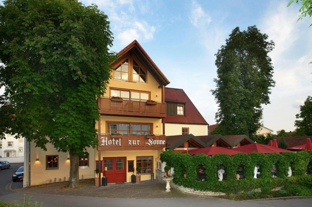 ein Hotel-Gasthof mit einem Baum davor in der Unterkunft Hotelgasthof zur Sonne in Bad Gögging