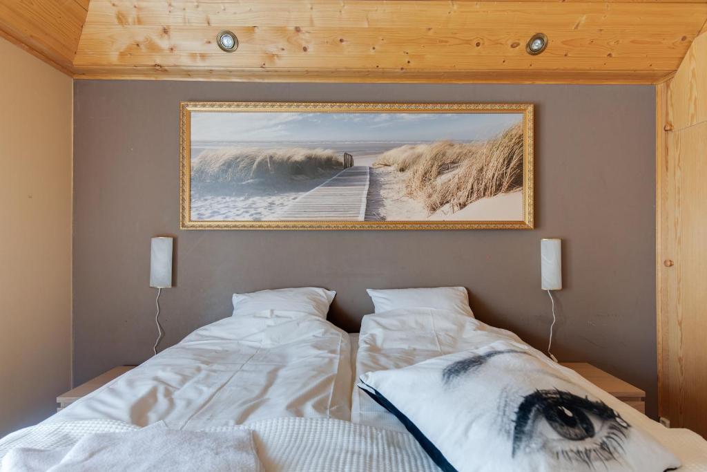 a bedroom with a bed with a picture on the wall at Klintvägen Apartments in Mariehamn