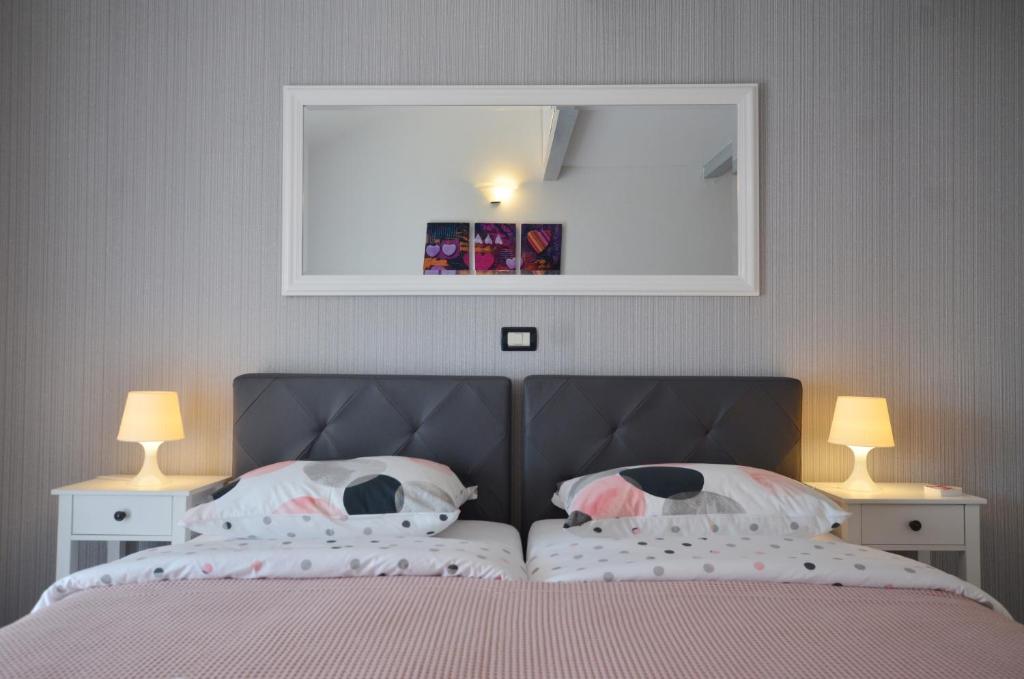 una camera con un letto con due lampade e uno specchio di Guesthouse Mila a Rovigno (Rovinj)