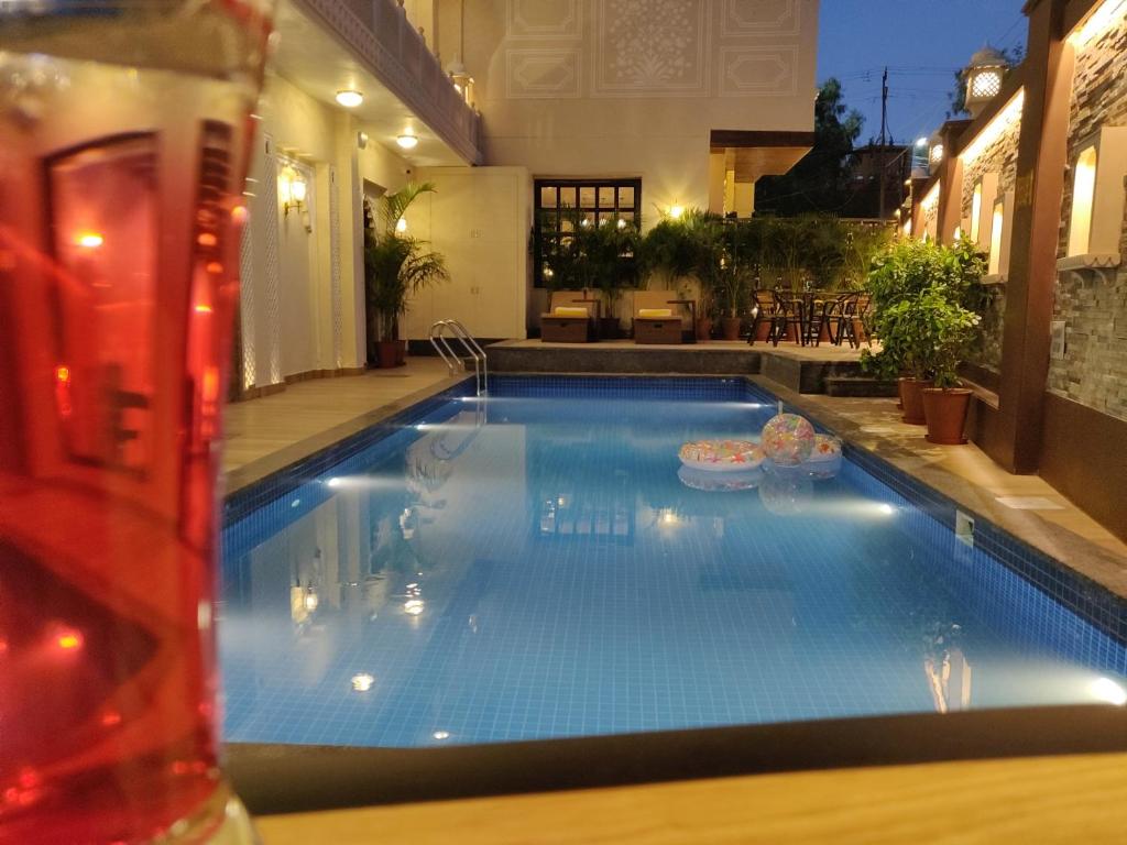 uma piscina numa casa com uma bebida em Laxmi Palace Heritage Boutique Hotel em Jaipur