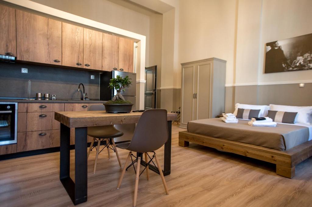 a bedroom with a bed and a table and a kitchen at City Lofts in Alexandroupoli