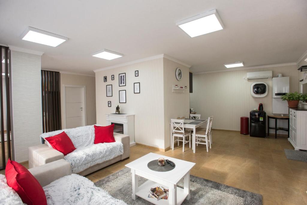 - un salon avec un canapé et une table dans l'établissement Lira Holiday Apartments, à Satu Mare