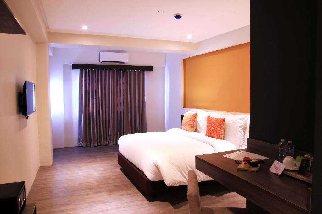 a bedroom with a bed and a table in a room at PROXY by The Oriental Albay in Legazpi