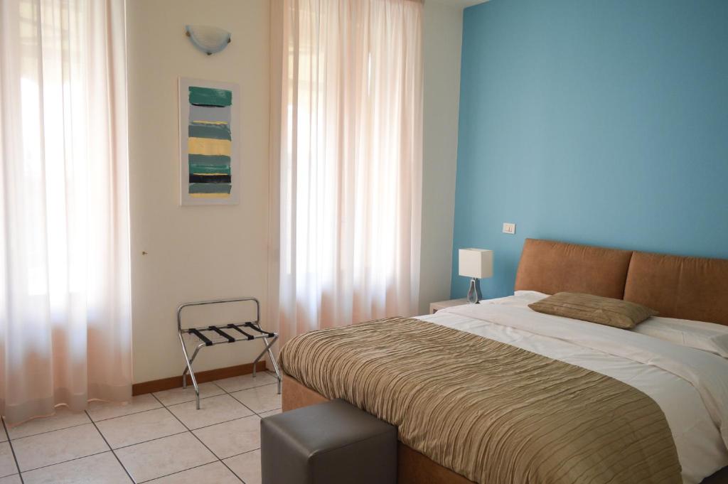 sypialnia z dużym łóżkiem i krzesłem w obiekcie La Contrada w mieście Sarnico