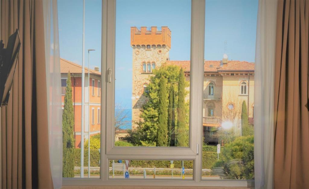 a window with a view of a building at Atico Hotel in Desenzano del Garda