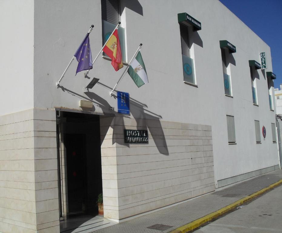un edificio con banderas a un lado. en Hostal San Marcos, en San Fernando