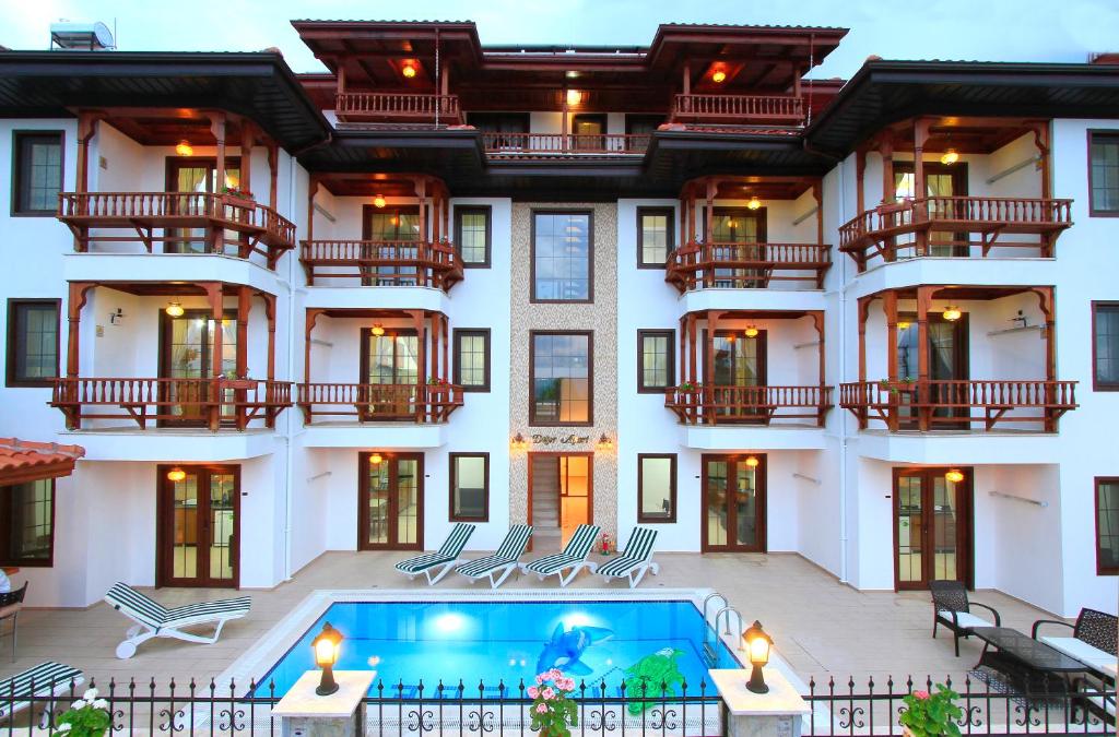 a large white building with a swimming pool in front of it at Akyaka Deger Apart in Akyaka