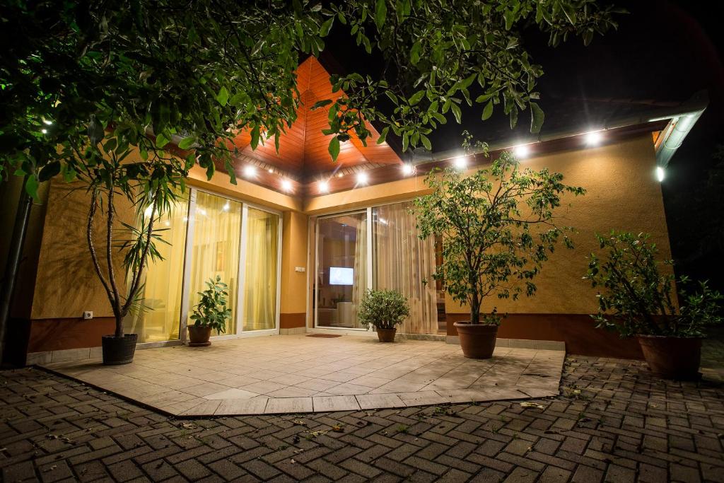 a building with a courtyard with potted plants and lights at Nyirfa Apartmanház Döröske in Döröske