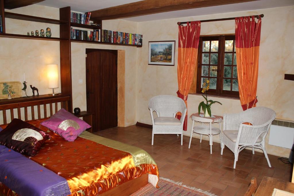 une chambre avec un lit, une table et des chaises dans l'établissement B&B Jardins de Vies, à Flayosc