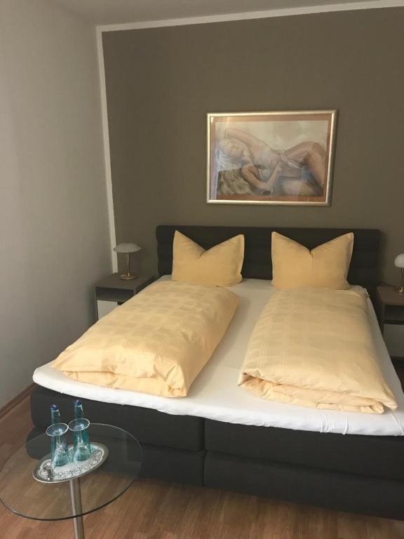 een slaapkamer met een groot bed en een glazen tafel bij Gasthof Wulf in Bremen