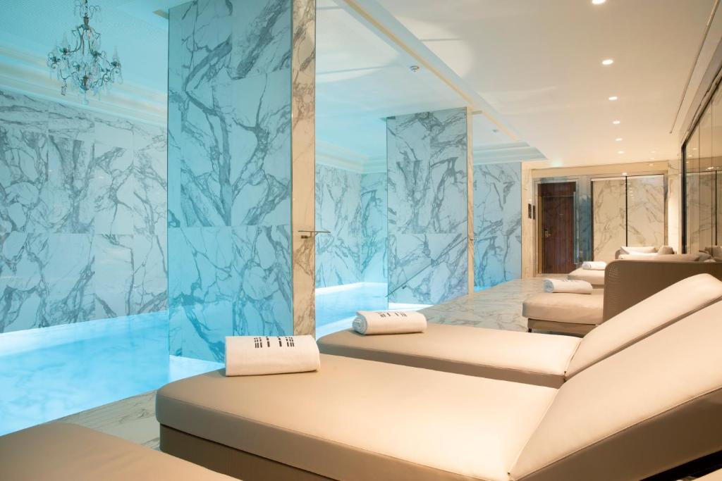 Cette chambre comprend 2 lits et une paroi en verre. dans l'établissement Le Damantin Hôtel & Spa, à Paris