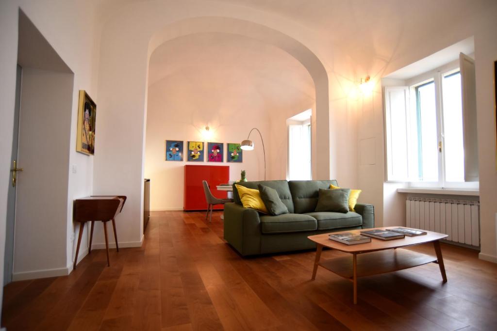 a living room with a green couch and a table at Suite Calderini in Perugia