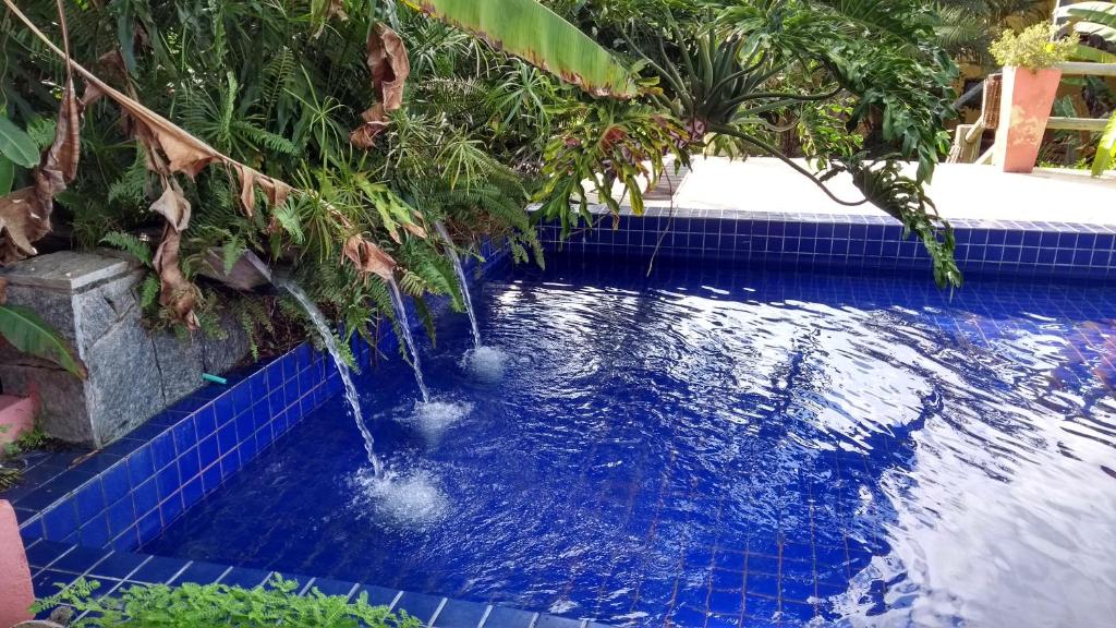 a pool with two fountains in the water at Bangalô no alto da colina no Villas do Pratagy - Maceió in Maceió