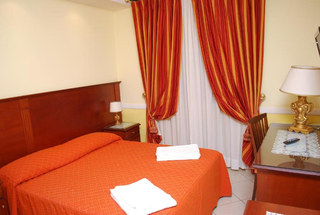 1 dormitorio con 1 cama y 1 mesa con lámpara en Hotel Valentino Palace, en Roma