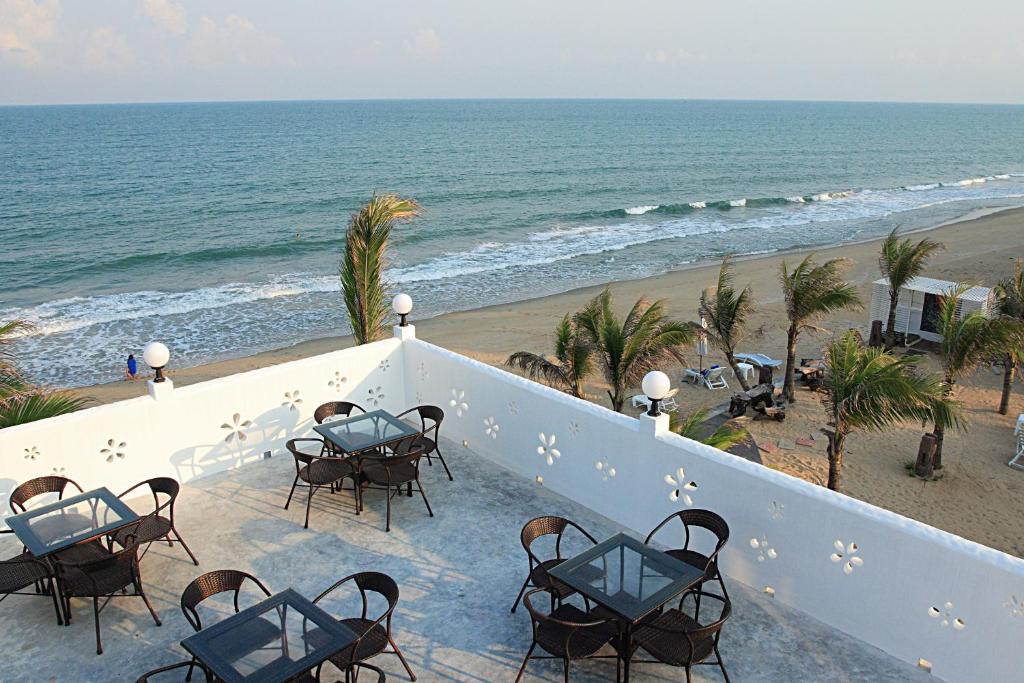 un balcón con mesas y sillas y la playa en Baanmontra Beach Resort - Bankrut en Ban Krut