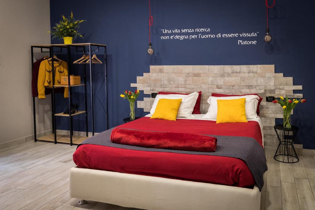 a bedroom with a large bed with red sheets and yellow pillows at B&B i Maestri in Naples