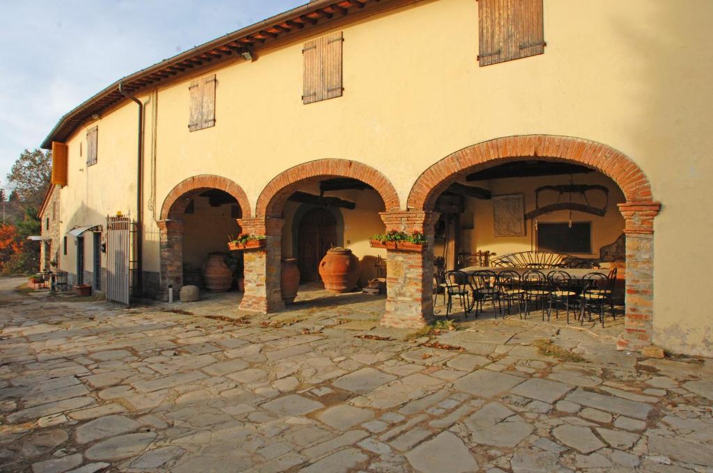 a building with a patio with tables and chairs at Agriturismo I Poggi in Impruneta