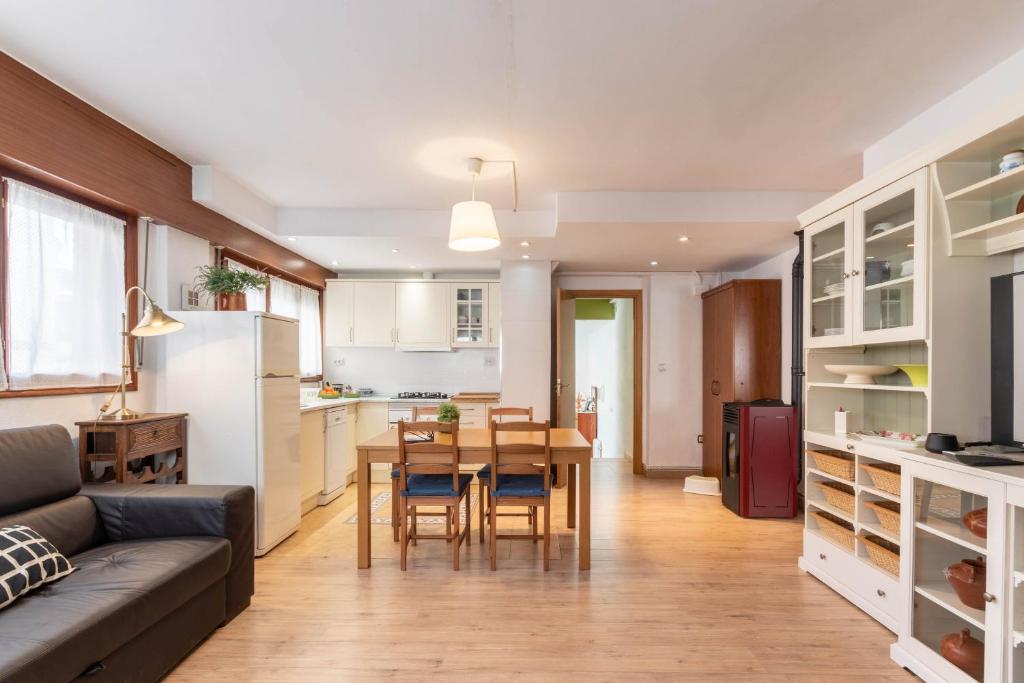 a kitchen and living room with a table and a couch at Mundaka Home in Mundaka