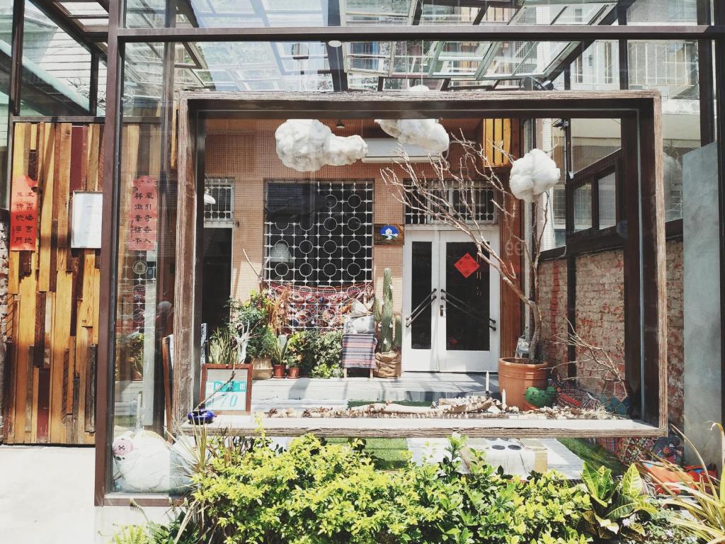 una finestra di un edificio con piante all’interno di GOIN Old House & Bar a Tainan