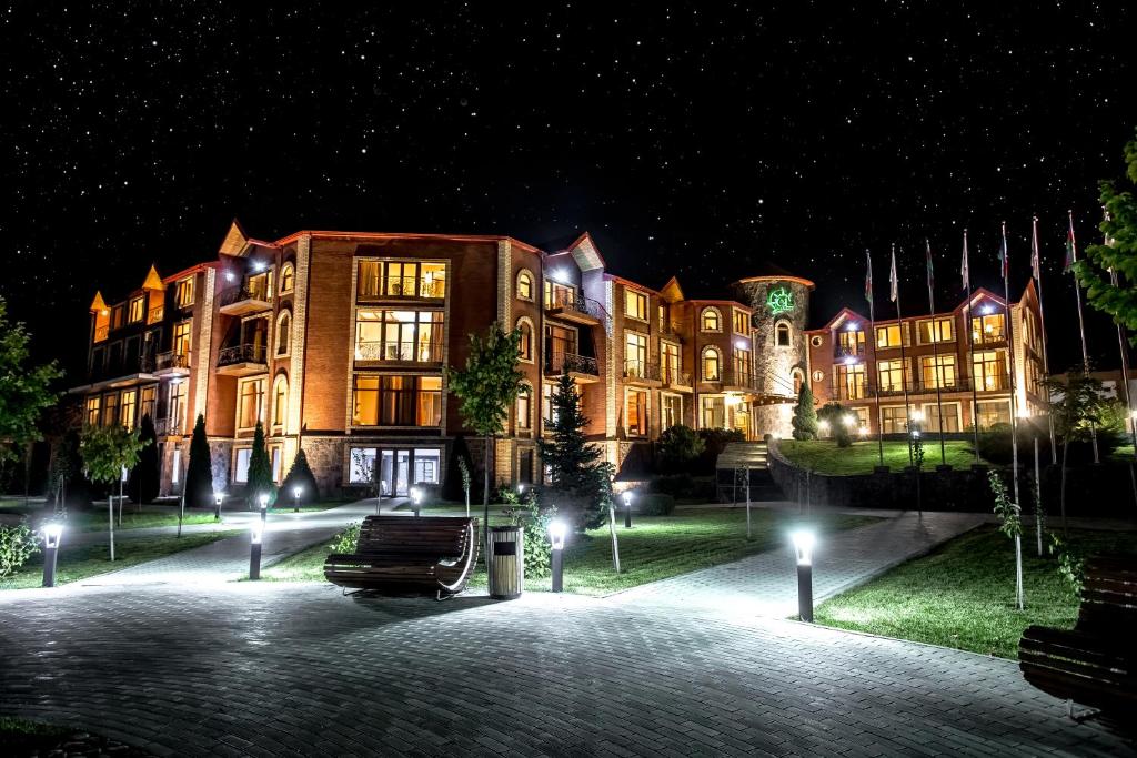 - un grand bâtiment la nuit avec des lumières devant dans l'établissement El Resort Hotel, à Qax