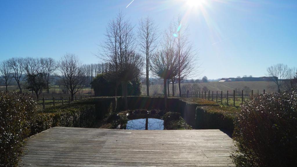 a wooden bridge over a small pond in a field at B&amp;B Onderweg in Horebeke