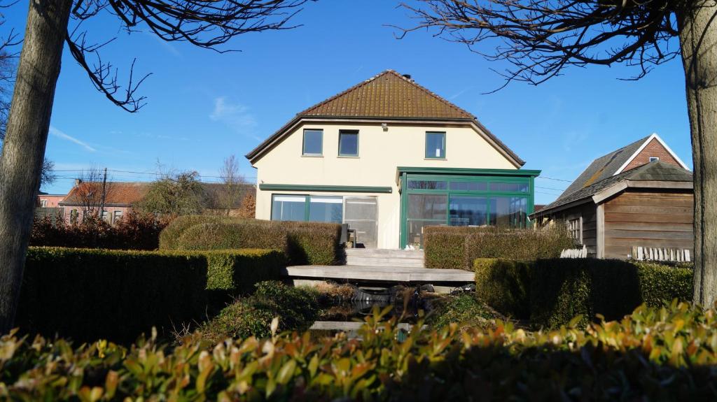 a white house with a picnic table in front of it at B&amp;B Onderweg in Horebeke