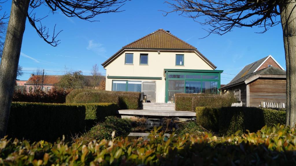 una casa blanca con una mesa de picnic delante de ella en B&B Onderweg, en Horebeke