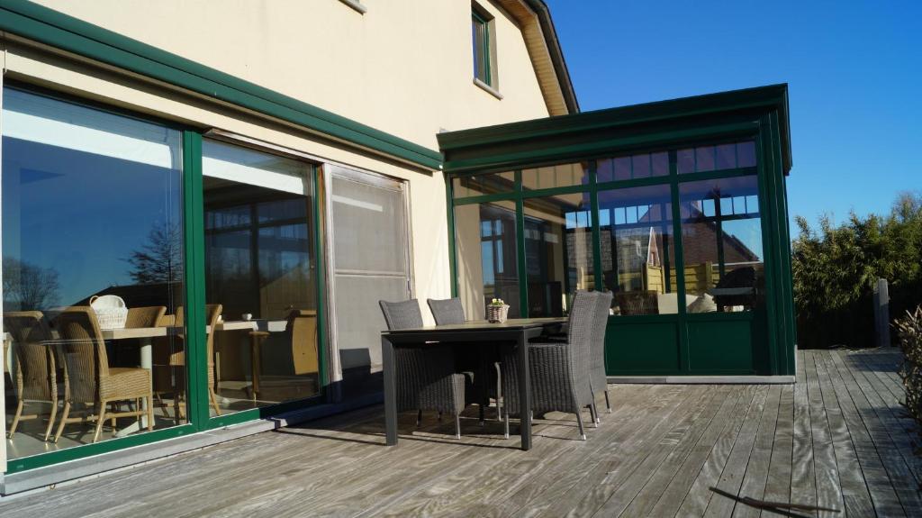 a patio with a table and chairs on a deck at B&amp;B Onderweg in Horebeke