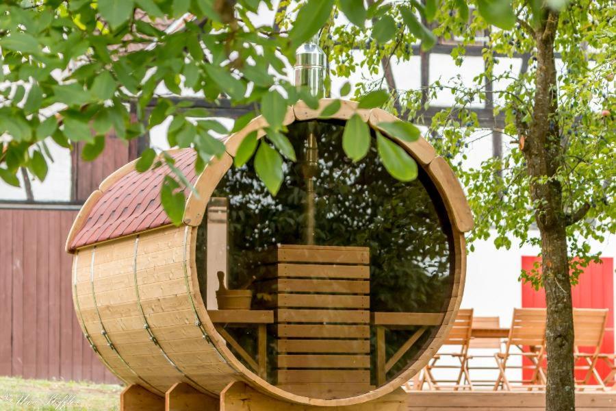 a wooden barrel with a house in the middle at Ferienhaus Rote Sau in Herrentierbach