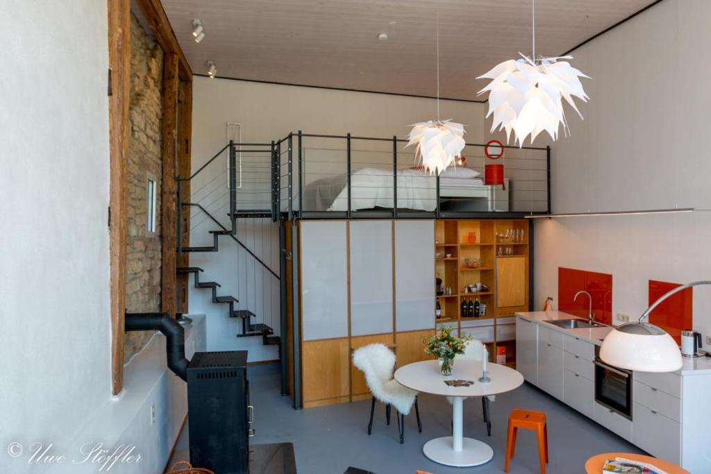een kamer met een trap en een tafel met stoelen bij Ferienhaus ScheunenRefugio in Rot am See