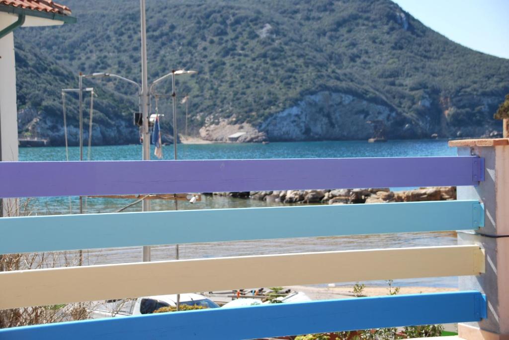 un banco azul con vistas al agua en Hotel Giardino delle Palme en Campese