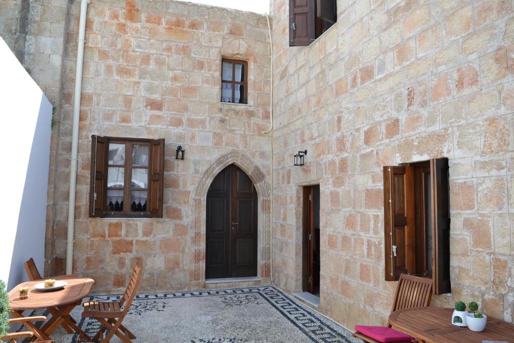 a patio with a table and chairs and a building at CasaLindos Festa in Lindos