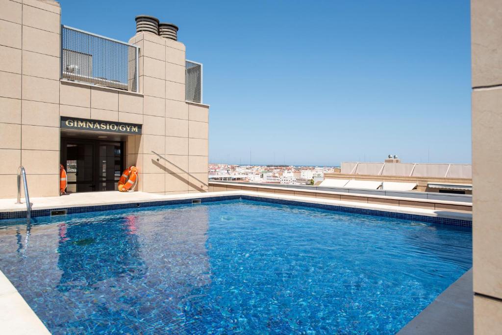 a swimming pool on the roof of a building at Hotel Valencia Center in Valencia