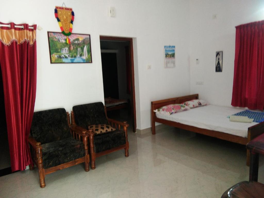 a small room with a bed and a chair at Nunu Homestay Guruvayoor in Guruvāyūr