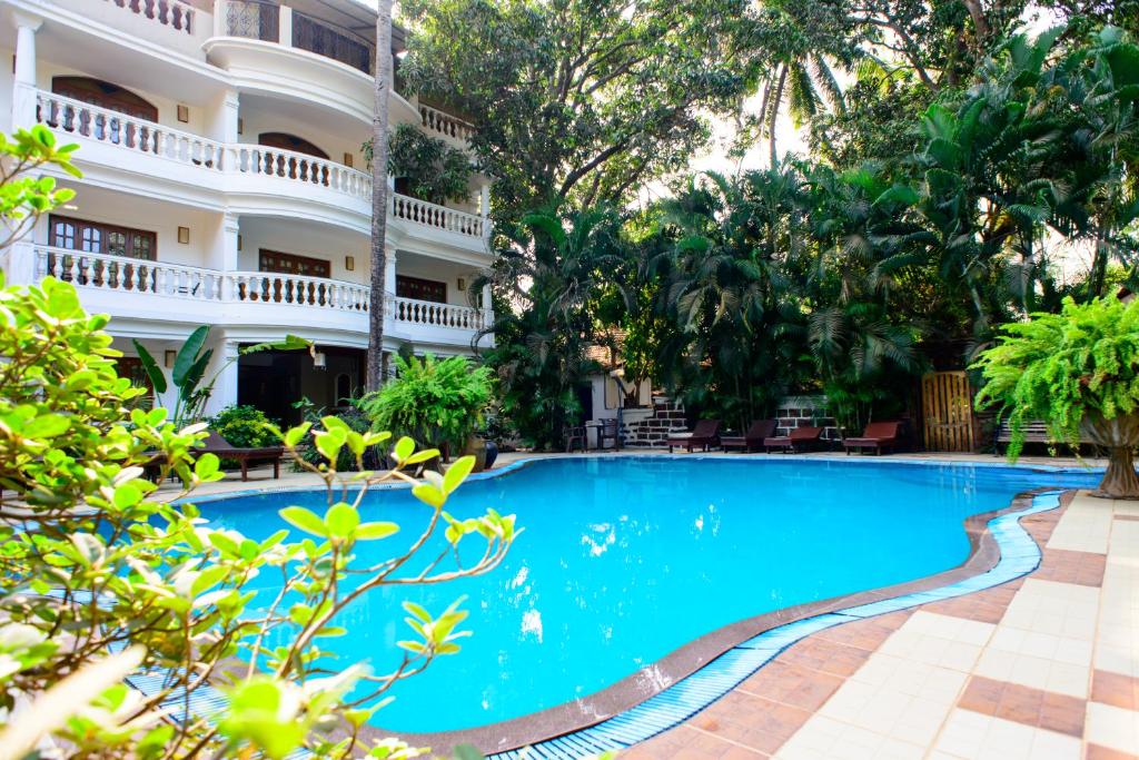 a swimming pool in front of a building at Bellflower Alidia Beach Resort in Baga